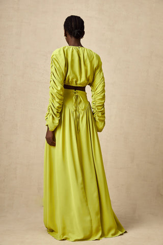 Model wearing a pistachio lime  green smocked long-sleeve crop top paired with a high-waisted pleated maxi skirt, perfect for summer and spring events. Two piece Skirt Set Maxi Long Sleeve - Vienna Shopping Brands to buy things to buy vienna christmas