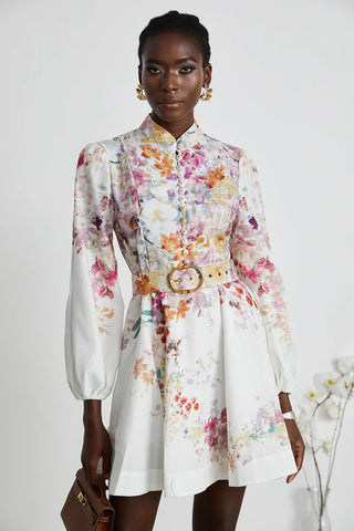 Model wearing Serafine Floral Mini Dress with long blouson sleeves and white multicolor floral print. Floral Mini Dress Spring