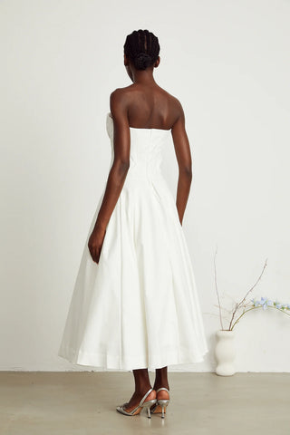 Elegant strapless white midi dress with corset-style bodice and pleated skirt, a chic House of CB dupe. Perfect as a minimalist bridal dress, with vintage-inspired elegance for weddings and formal events.