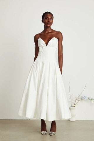 Elegant strapless white midi dress with corset-style bodice and pleated skirt, a chic House of CB dupe. Perfect as a minimalist bridal dress, with vintage-inspired elegance for weddings and formal events.