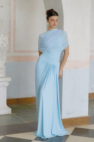 Elegant baby blue asymmetric pleated maxi dress with draped shawl detail, perfect as a wedding guest dress, baby shower dress, or formal evening gown. Sleeveless floor-length blue dress with a figure-flattering fit, ideal for gender reveal parties, spring and summer weddings, and special occasions. Shop this chic and sophisticated pleated maxi dress for a timeless and graceful look.