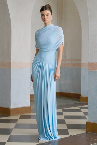 Elegant baby blue asymmetric pleated maxi dress with draped shawl detail, perfect as a wedding guest dress, baby shower dress, or formal evening gown. Sleeveless floor-length blue dress with a figure-flattering fit, ideal for gender reveal parties, spring and summer weddings, and special occasions. Shop this chic and sophisticated pleated maxi dress for a timeless and graceful look.