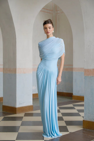 Elegant baby blue asymmetric pleated maxi dress with draped shawl detail, perfect as a wedding guest dress, baby shower dress, or formal evening gown. Sleeveless floor-length blue dress with a figure-flattering fit, ideal for gender reveal parties, spring and summer weddings, and special occasions. Shop this chic and sophisticated pleated maxi dress for a timeless and graceful look.