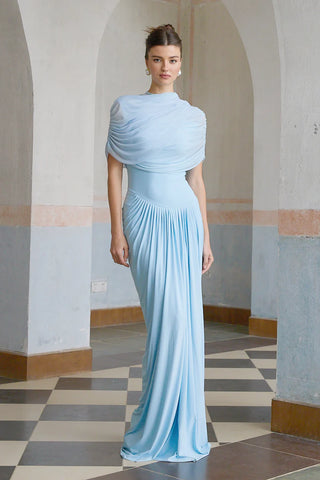 Elegant baby blue asymmetric pleated maxi dress with draped shawl detail, perfect as a wedding guest dress, baby shower dress, or formal evening gown. Sleeveless floor-length blue dress with a figure-flattering fit, ideal for gender reveal parties, spring and summer weddings, and special occasions. Shop this chic and sophisticated pleated maxi dress for a timeless and graceful look.