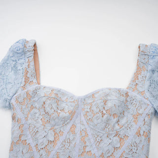 Model wearing baby blue lace midi dress with corset bodice and short lace sleeves