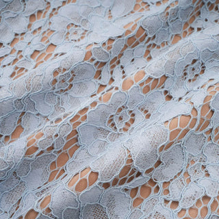 Model wearing baby blue lace midi dress with corset bodice and short lace sleeves