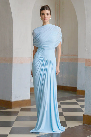 Elegant baby blue asymmetric pleated maxi dress with draped shawl detail, perfect as a wedding guest dress, baby shower dress, or formal evening gown. Sleeveless floor-length blue dress with a figure-flattering fit, ideal for gender reveal parties, spring and summer weddings, and special occasions. Shop this chic and sophisticated pleated maxi dress for a timeless and graceful look.