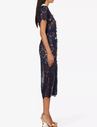 Model wearing navy guipure lace midi dress with white contrast collar and gold buttons Austrian Fashion Brand