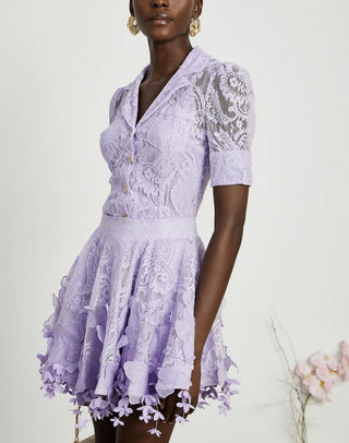 Woman wearing a lavender lace two-piece summer set with short-sleeve buttoned top and floral embroidered flared skirt, perfect for vacation or coastal getaway.