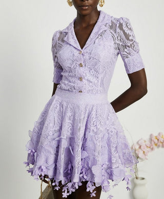 Woman wearing a lavender lace two-piece summer set with short-sleeve buttoned top and floral embroidered flared skirt, perfect for vacation or coastal getaway.