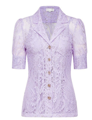 Woman wearing a lavender lace two-piece summer set with short-sleeve buttoned top and floral embroidered flared skirt, perfect for vacation or coastal getaway.