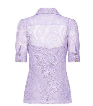 Woman wearing a lavender lace two-piece summer set with short-sleeve buttoned top and floral embroidered flared skirt, perfect for vacation or coastal getaway.