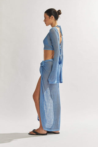 Blue crocheted long-sleeve crop top with open back and matching tie-side skirt, shown from side angle highlighting texture and silhouette. Beach Dress cover up blue