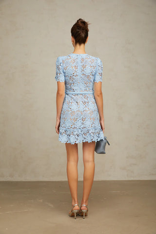 Model wearing Isola baby blue guipure lace mini dress with floral appliqué and belted waist