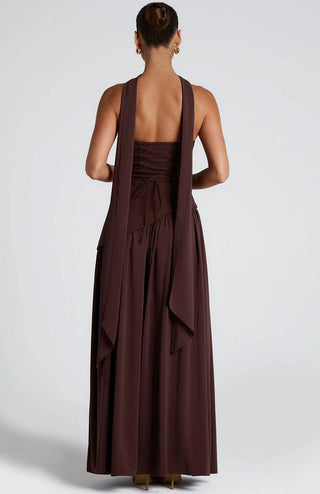 Woman in rich brown maxi dress with scarf at formal outdoor wedding setting, styled with nude heels. scarf