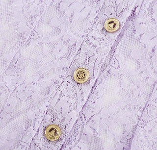 Woman wearing a lavender lace two-piece summer set with short-sleeve buttoned top and floral embroidered flared skirt, perfect for vacation or coastal getaway.