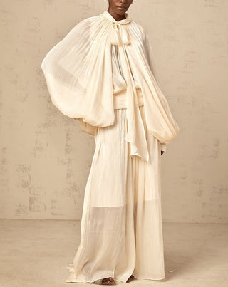 Elegant ivory satin gown styled for modern modest bride – long sleeve wedding maxi dress with flowing silhouette.