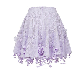 Woman wearing a lavender lace two-piece summer set with short-sleeve buttoned top and floral embroidered flared skirt, perfect for vacation or coastal getaway.
