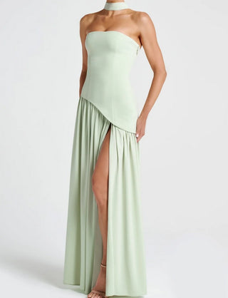 Model wearing mint green strapless maxi dress with asymmetrical crepe bodice, full chiffon skirt, and thigh-high slit.