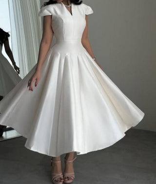 Minimalist ivory bridal dress with structured bodice and elegant flare
