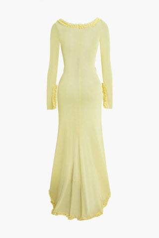 Elegant yellow beach dress with transparent mesh fabric and ruffled details, styled as a bikini cover-up on the grass at a resort.