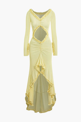 Elegant yellow beach dress with transparent mesh fabric and ruffled details, styled as a bikini cover-up on the grass at a resort.