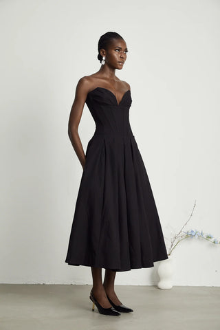 Elegant black strapless corset midi dress with pleated skirt, V-neckline, and off-the-shoulder design. A chic dupe for House of CB dresses, perfect for formal events and cocktail parties. Cielie Vienna Lady