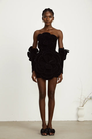 Model wearing a black velvet off-the-shoulder dress with large floral appliqué detailing and matching gloves, perfect for holiday parties, Christmas, and New Year's celebrations.