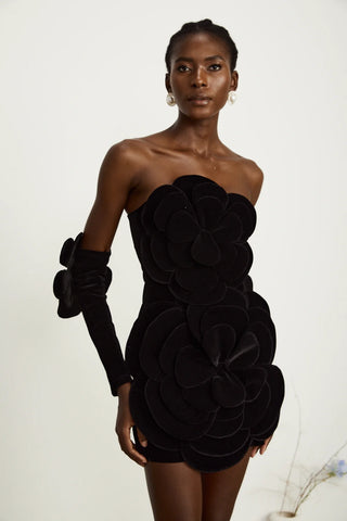 Model wearing a black velvet off-the-shoulder dress with large floral appliqué detailing and matching gloves, perfect for holiday parties, Christmas, and New Year's celebrations.