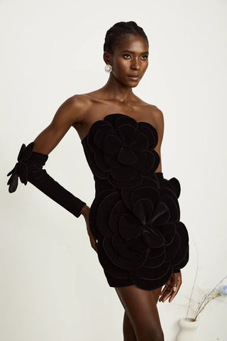 Model wearing a black velvet off-the-shoulder dress with large floral appliqué detailing and matching gloves, perfect for holiday parties, Christmas, and New Year's celebrations.