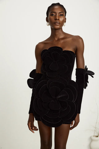 Model wearing a black velvet off-the-shoulder dress with large floral appliqué detailing and matching gloves, perfect for holiday parties, Christmas, and New Year's celebrations.