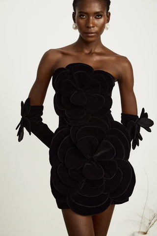 Model wearing a black velvet off-the-shoulder dress with large floral appliqué detailing and matching gloves, perfect for holiday parties, Christmas, and New Year's celebrations.