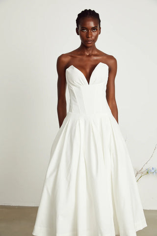 Elegant strapless white midi dress with corset-style bodice and pleated skirt, a chic House of CB dupe. Perfect as a minimalist bridal dress, with vintage-inspired elegance for weddings and formal events.