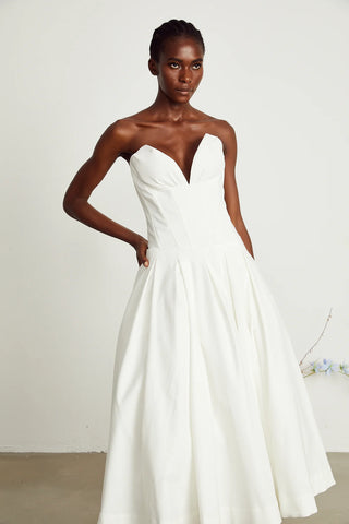 Elegant strapless white midi dress with corset-style bodice and pleated skirt, a chic House of CB dupe. Perfect as a minimalist bridal dress, with vintage-inspired elegance for weddings and formal events.