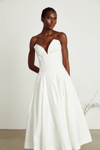 Elegant strapless white midi dress with corset-style bodice and pleated skirt, a chic House of CB dupe. Perfect as a minimalist bridal dress, with vintage-inspired elegance for weddings and formal events.