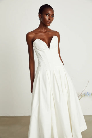 legant strapless white midi dress with corset-style bodice and pleated skirt, a chic House of CB dupe. Perfect as a minimalist bridal dress, with vintage-inspired elegance for weddings and formal events.