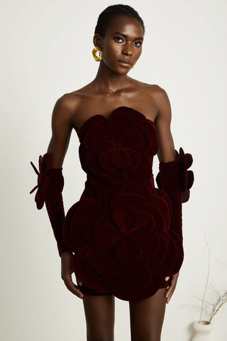 Model wearing a wine-red velvet off-the-shoulder dress with large floral appliqué detailing and matching gloves, creating an elegant and sophisticated look for special occasions. Cielie Vienna Fashion 