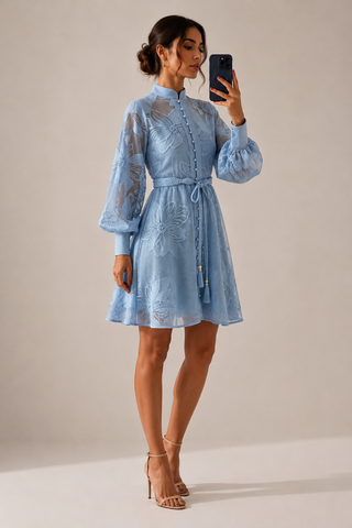 Powder blue floral lace mini dress featuring intricate embroidered lace, sheer long sleeves, high neckline, detachable braided waist belt, coordinating slip dress, fit and flare silhouette, and concealed back zipper closure, perfect for wedding guests, baby showers, bridal showers, garden parties, and elegant spring or summer occasions.