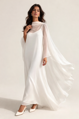 Woman wearing a flowing white dress with a plain background