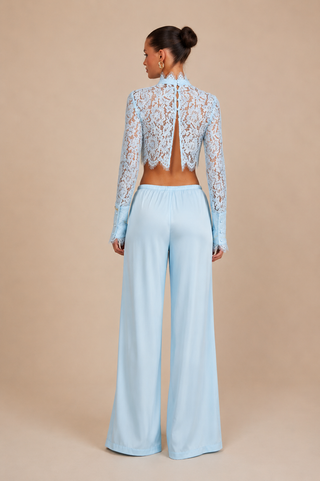 Back view of AULA baby blue floral lace crop top featuring open back button detail with matching satin wide leg trousers, elegant European vacation outfit for beach clubs and luxury summer holidays.