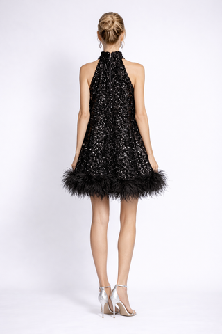 Black sequin dress with feather details on a white background
