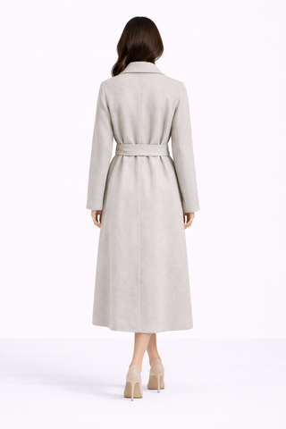 Woman wearing a long beige coat on a white background