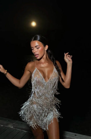 Woman in a silver beaded dress against a dark background - rhinestone fringe mini dress silvester new years party glitter 