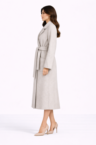 Woman wearing a long beige coat on a white background