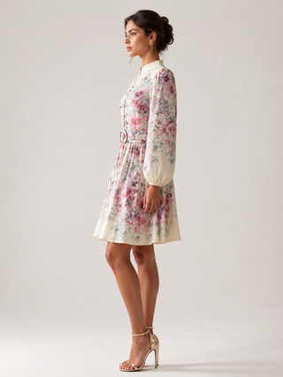 Romantic floral mini dress featuring a watercolor floral print in pink, lavender, lilac, and ivory tones, high neckline, long sleeves, matching waist belt, fit and flare silhouette, and flowing lightweight fabric, perfect for wedding guests, baby showers, bridal showers, garden parties, brunches, and elegant spring or summer occasions.