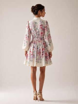 Romantic floral mini dress featuring a watercolor floral print in pink, lavender, lilac, and ivory tones, high neckline, long sleeves, matching waist belt, fit and flare silhouette, and flowing lightweight fabric, perfect for wedding guests, baby showers, bridal showers, garden parties, brunches, and elegant spring or summer occasions.
