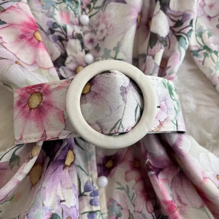 Floral-patterned fabric with a white circular object and pink bow