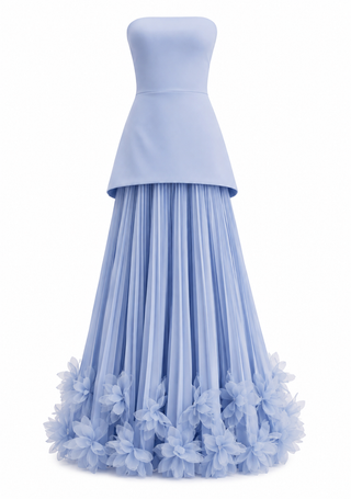 A strapless light blue gown with a structured peplum waist and a voluminous pleated skirt adorned with layered floral appliqué along the hem, shown on a plain white background.