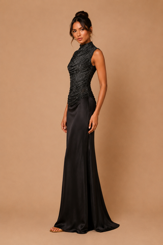 Elegant black two-piece set featuring a ruched high-neck shimmer top and satin maxi skirt, modest wedding guest outfit, luxury eveningwear, formal occasion co-ord.