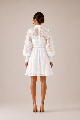 White floral lace mini dress featuring intricate embroidered lace, sheer long sleeves, high neckline, detachable braided waist belt, coordinating slip dress, fit and flare silhouette, and concealed back zipper closure, perfect for bridal showers, engagement parties, courthouse weddings, white parties, graduations, vacations, and elegant summer occasions.